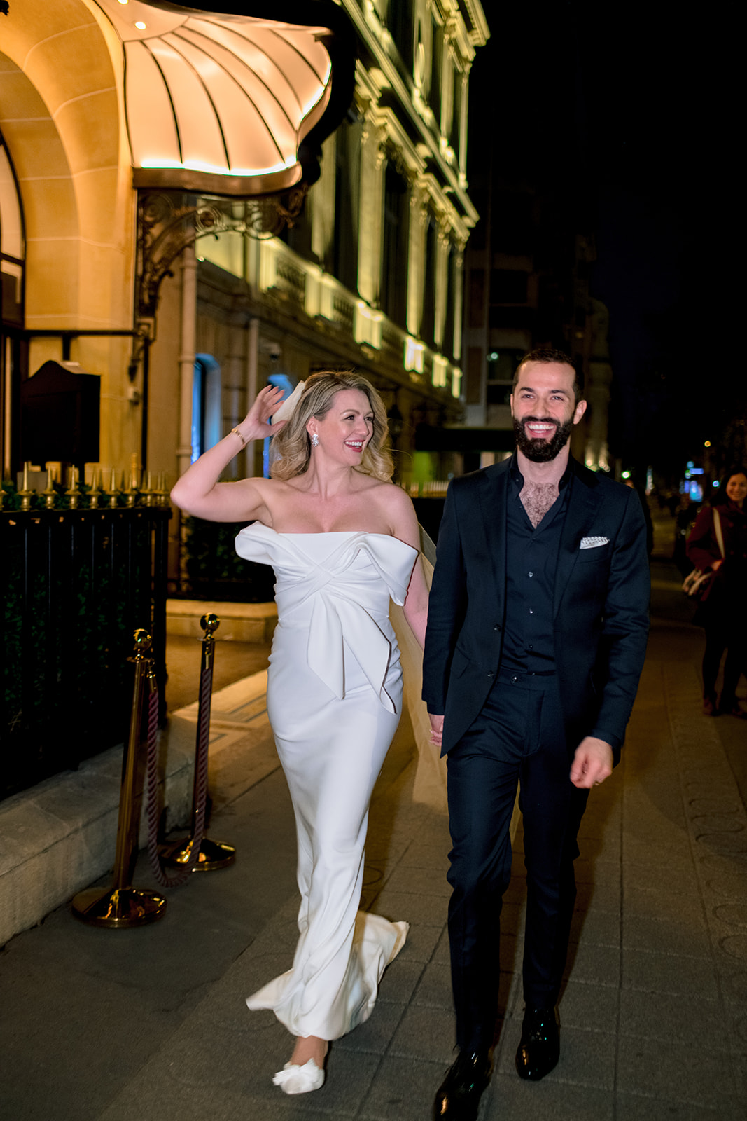 Bride and groom walking together on Avenue Montaigne at night